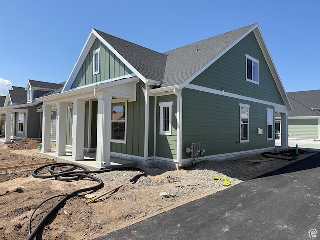 6 S 3830 W Unit 417, West Point, UT 84015 - view of property exterior featuring board and batten siding, roof with shingles, and a porch