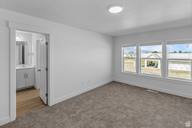 3175 S 208 W, Nibley, UT 84321 - unfurnished bedroom with visible vents, baseboards, connected bathroom, a sink, and carpet floors