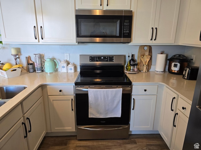 15 W Seasons Dr, Vineyard, UT 84059 - kitchen featuring stainless steel appliances, white cabinets, light countertops, and dark wood-style floors