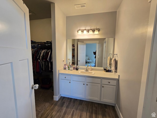 15 W Seasons Dr, Vineyard, UT 84059 - bathroom with vanity, wood finished floors, a walk in closet, and baseboards