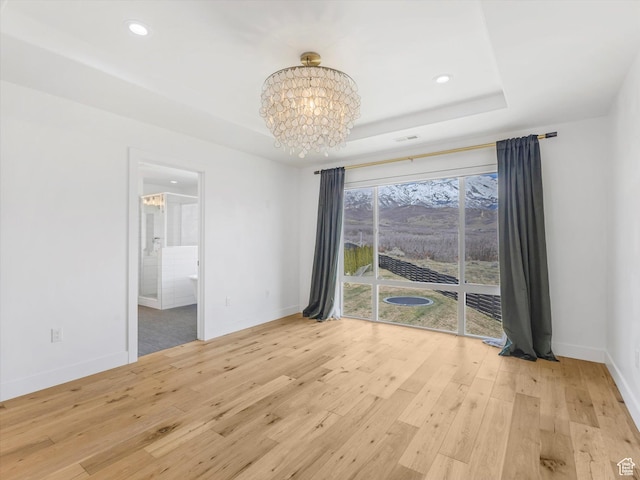 12224 N Bridgegate Way, Highland, UT 84003 - empty room with baseboards, a tray ceiling, an inviting chandelier, and light wood finished floors