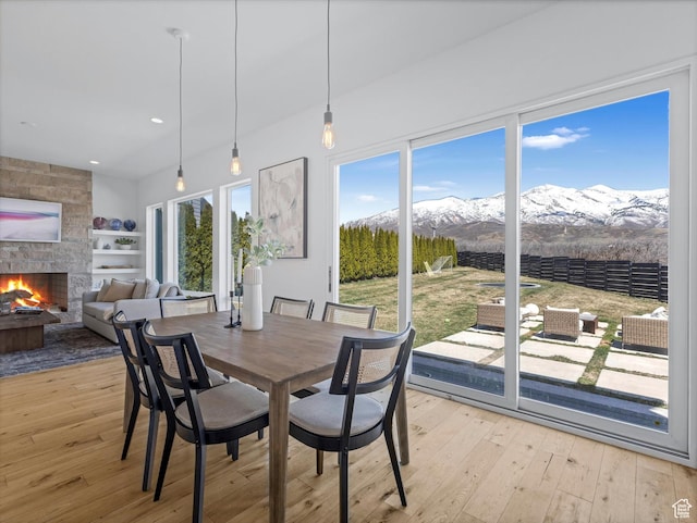 12224 N Bridgegate Way, Highland, UT 84003 - dining area featuring light wood-type flooring, recessed lighting, a mountain view, and a fireplace