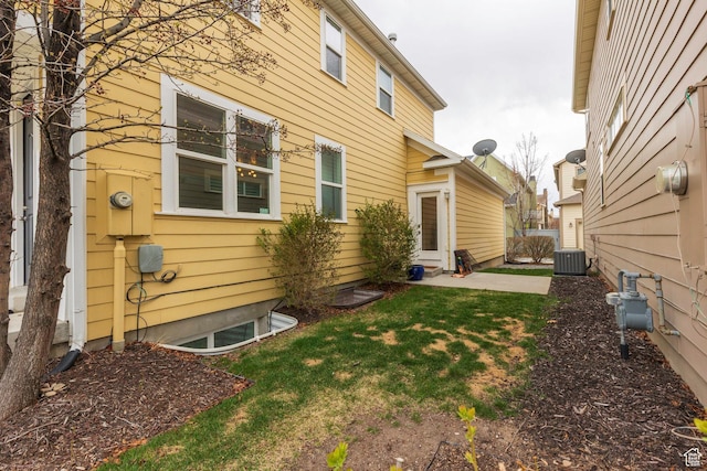 view of home's exterior featuring central AC unit and a yard