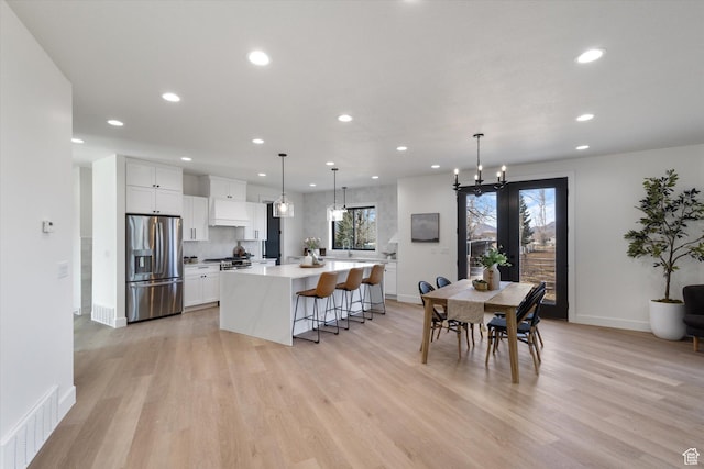 dining room featuring baseboards, visible vents, recessed lighting, and light wood finished floors