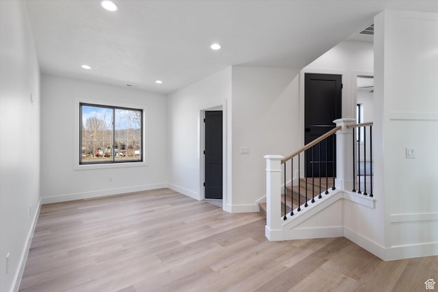 spare room with recessed lighting, baseboards, and light wood-type flooring