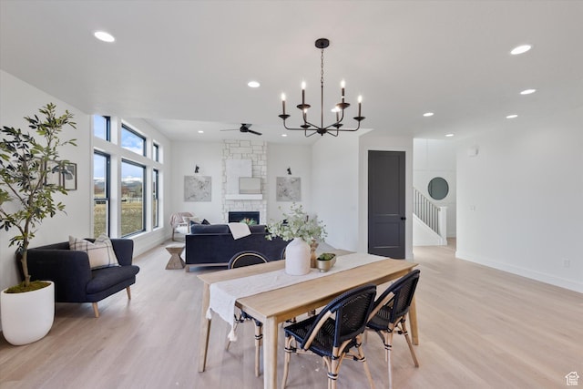 dining space with recessed lighting, light wood-style floors, a ceiling fan, and a stone fireplace