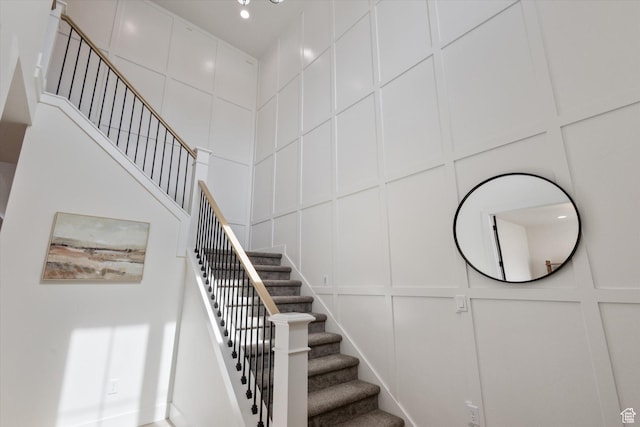 stairway featuring a decorative wall