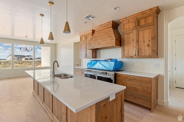 4416 W 1900 S, Cedar City, UT 84720 - kitchen featuring premium range hood, a sink, stainless steel gas range oven, a spacious island, and pendant lighting