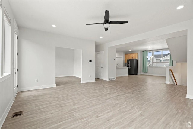 13192 S Lowick Ln, Herriman, UT 84096 - unfurnished living room featuring visible vents, baseboards, recessed lighting, a ceiling fan, and light wood-type flooring