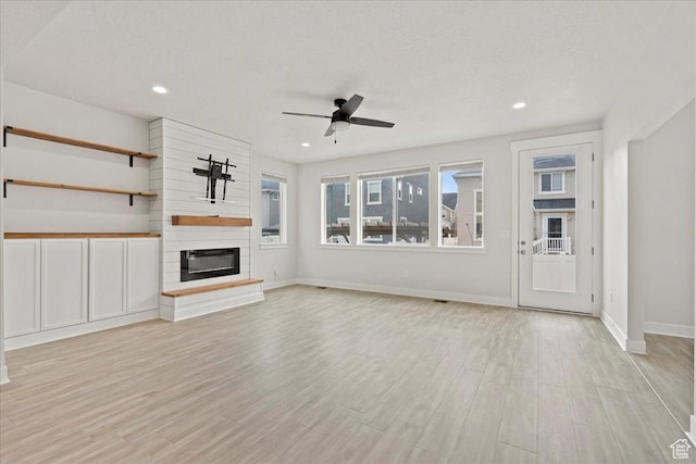 13192 S Lowick Ln, Herriman, UT 84096 - unfurnished living room with light wood finished floors, baseboards, ceiling fan, and a textured ceiling