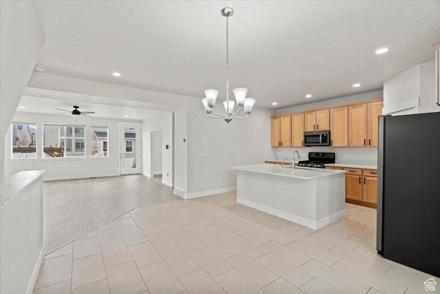 13192 S Lowick Ln, Herriman, UT 84096 - kitchen with light countertops, a kitchen island with sink, gas stove, open floor plan, and freestanding refrigerator