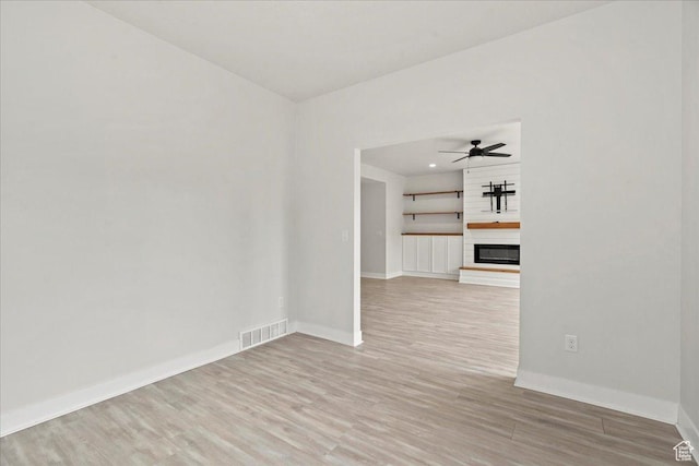 13192 S Lowick Ln, Herriman, UT 84096 - empty room featuring visible vents, light wood finished floors, baseboards, ceiling fan, and a fireplace