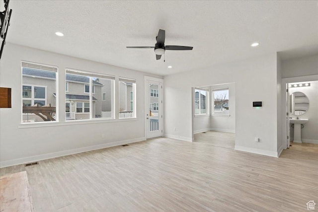 13192 S Lowick Ln, Herriman, UT 84096 - unfurnished living room with a ceiling fan, baseboards, light wood-style flooring, and visible vents