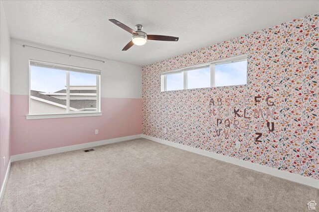 13192 S Lowick Ln, Herriman, UT 84096 - carpeted spare room with wallpapered walls, a textured ceiling, baseboards, visible vents, and ceiling fan
