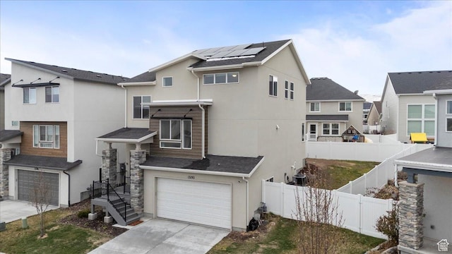 13192 S Lowick Ln, Herriman, UT 84096 - view of front of home with concrete driveway, stucco siding, a fenced backyard, solar panels, and a garage