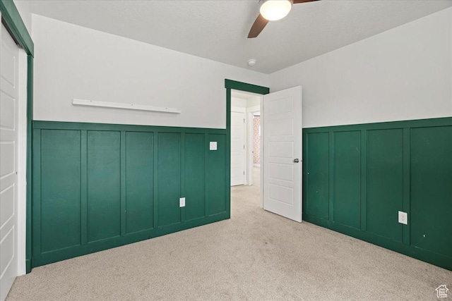 13192 S Lowick Ln, Herriman, UT 84096 - unfurnished bedroom with carpet flooring, a textured ceiling, a decorative wall, a wainscoted wall, and a ceiling fan