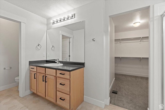 13192 S Lowick Ln, Herriman, UT 84096 - full bathroom featuring toilet, vanity, a spacious closet, and a textured ceiling