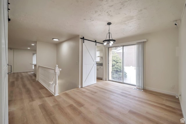 4195 W Kirkcaldy Cir S, South Jordan, UT 84009 - unfurnished dining area featuring visible vents, baseboards, light wood finished floors, and a barn door