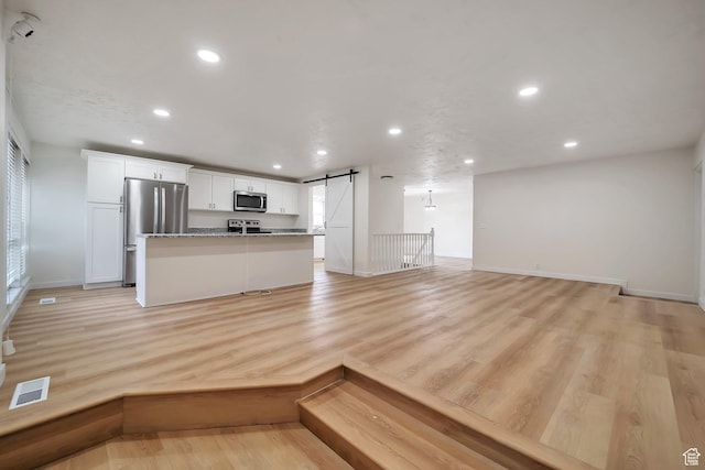 4195 W Kirkcaldy Cir S, South Jordan, UT 84009 - unfurnished living room featuring visible vents, recessed lighting, a barn door, light wood finished floors, and baseboards