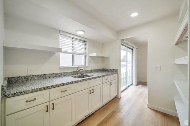 4195 W Kirkcaldy Cir S, South Jordan, UT 84009 - kitchen featuring baseboards, open shelves, a sink, light wood finished floors, and light stone countertops