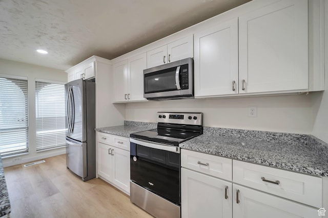 4195 W Kirkcaldy Cir S, South Jordan, UT 84009 - kitchen featuring white cabinetry, appliances with stainless steel finishes, stone countertops, and light wood-style floors