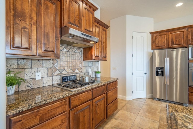 2104 S Corral Way, Washington, UT 84780 - kitchen with light tile patterned flooring, stainless steel appliances, under cabinet range hood, dark stone countertops, and backsplash