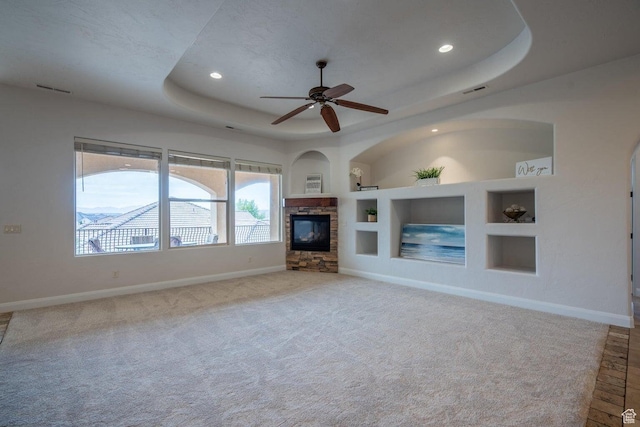 2104 S Corral Way, Washington, UT 84780 - unfurnished living room featuring a tray ceiling, built in shelves, a fireplace, baseboards, and carpet