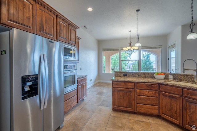 2104 S Corral Way, Washington, UT 84780 - kitchen featuring stainless steel appliances, dark stone counters, a sink, pendant lighting, and a notable chandelier