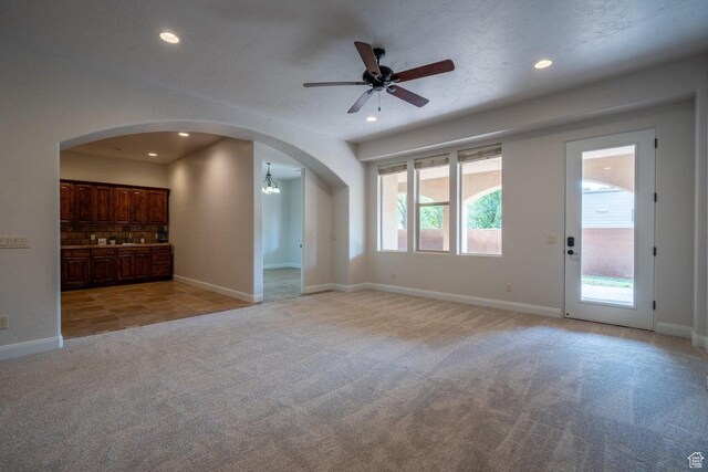 2104 S Corral Way, Washington, UT 84780 - unfurnished living room with arched walkways, recessed lighting, and light carpet
