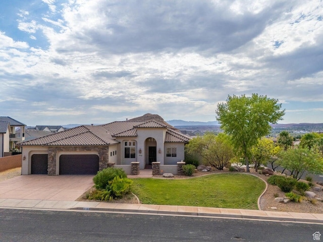 2104 S Corral Way, Washington, UT 84780 - mediterranean / spanish home featuring a tile roof, stucco siding, driveway, a front lawn, and a garage