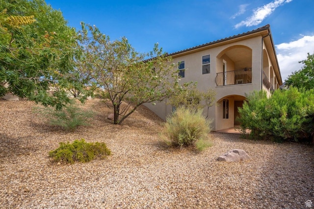 2104 S Corral Way, Washington, UT 84780 - back of property featuring stucco siding, a tiled roof, and a balcony