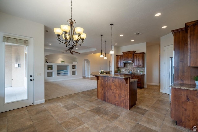 2104 S Corral Way, Washington, UT 84780 - kitchen featuring a kitchen island, built in features, under cabinet range hood, visible vents, and arched walkways