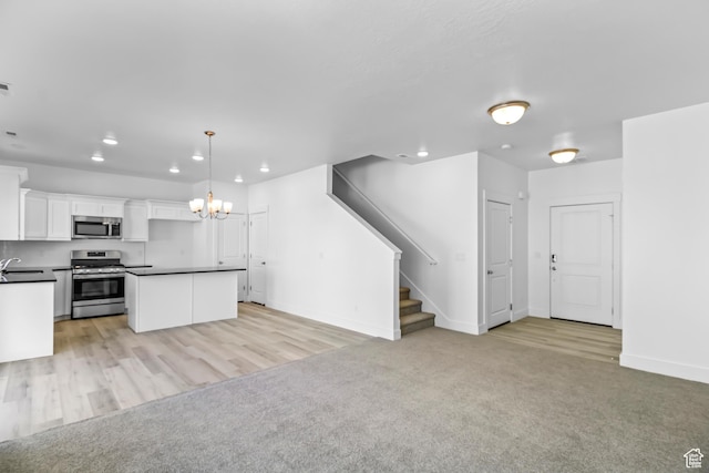 3205 N 3500 W Unit 378, Plain City, UT 84404 - kitchen featuring a chandelier, a sink, dark countertops, light carpet, and appliances with stainless steel finishes