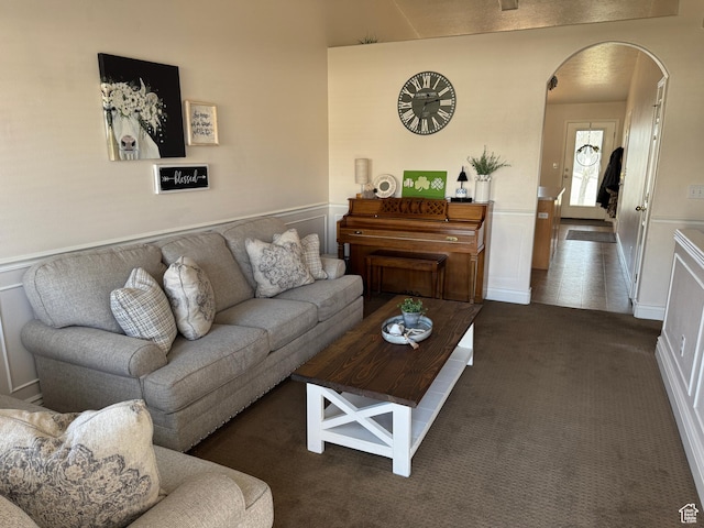 4625 W Harvey Blvd, Cedar Hills, UT 84062 - living area featuring arched walkways, a wainscoted wall, a decorative wall, and dark carpet
