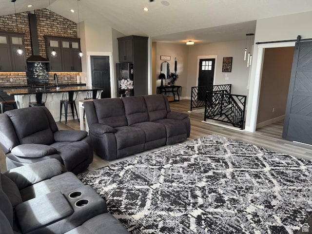 340 E 300 N, Moroni, UT 84646 - living area with a barn door, vaulted ceiling, light wood-style floors, baseboards, and recessed lighting