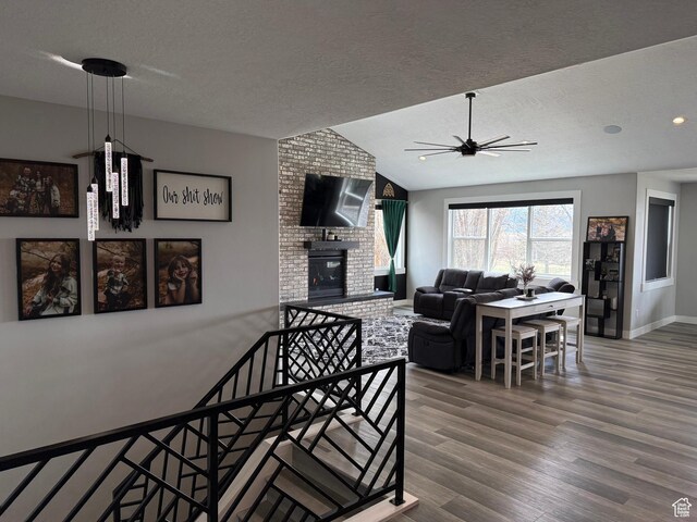 340 E 300 N, Moroni, UT 84646 - living area with a textured ceiling, ceiling fan, lofted ceiling, wood finished floors, and a brick fireplace