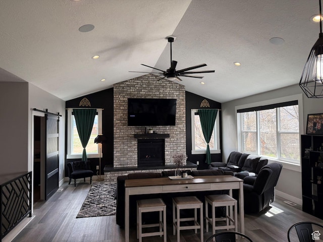 340 E 300 N, Moroni, UT 84646 - living area featuring a textured ceiling, lofted ceiling, wood finished floors, a ceiling fan, and a brick fireplace