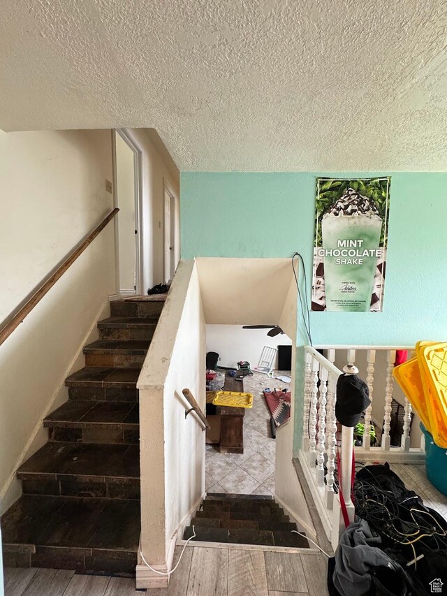 627 E Valley View Dr, Tooele, UT 84074 - staircase featuring a textured ceiling and wood finished floors