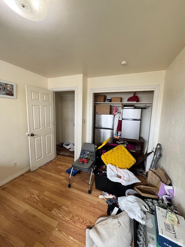 627 E Valley View Dr, Tooele, UT 84074 - bedroom featuring a closet, a textured ceiling, baseboards, wood finished floors, and freestanding refrigerator