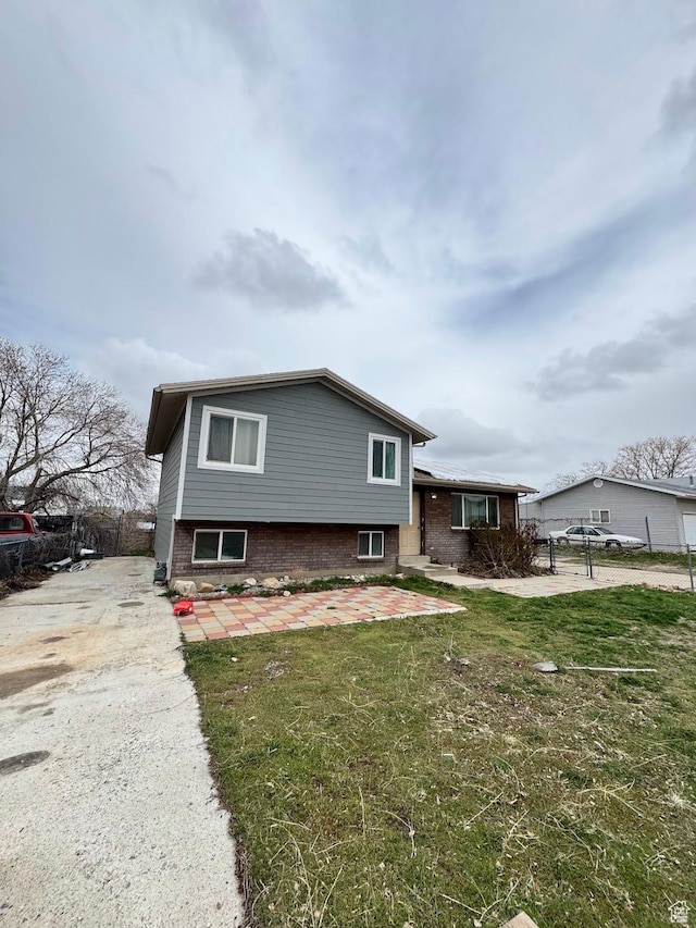 627 E Valley View Dr, Tooele, UT 84074 - view of front of property featuring a front lawn, driveway, a patio, and brick siding