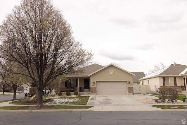 single story home featuring a gate, an attached garage, stucco siding, brick siding, and driveway