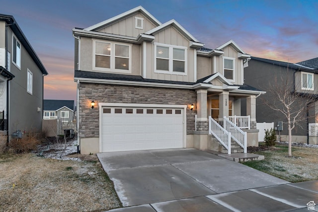 view of front of property with stone siding, board and batten siding, covered porch, and an attached garage