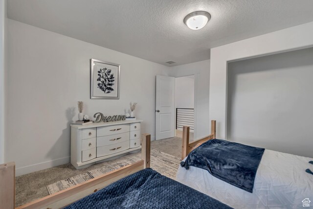 138 N Valcrest Dr, Saratoga Springs, UT 84045 - bedroom with visible vents, light carpet, baseboards, and a textured ceiling