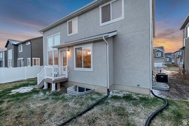 138 N Valcrest Dr, Saratoga Springs, UT 84045 - back of property at dusk featuring stucco siding, fence, and central AC unit