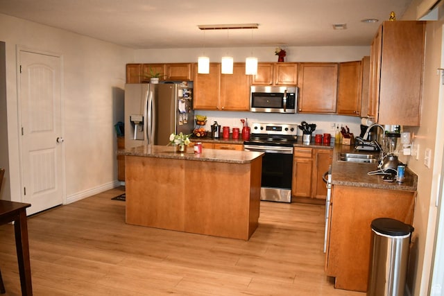 148 N Walton Ct W, North Salt Lake, UT 84054 - kitchen featuring a kitchen island, appliances with stainless steel finishes, a sink, light wood-style floors, and brown cabinetry