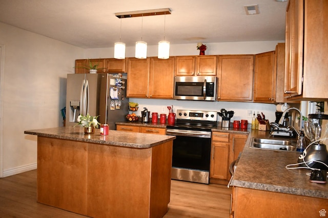 148 N Walton Ct W, North Salt Lake, UT 84054 - kitchen with a sink, appliances with stainless steel finishes, a center island, light wood-type flooring, and dark countertops