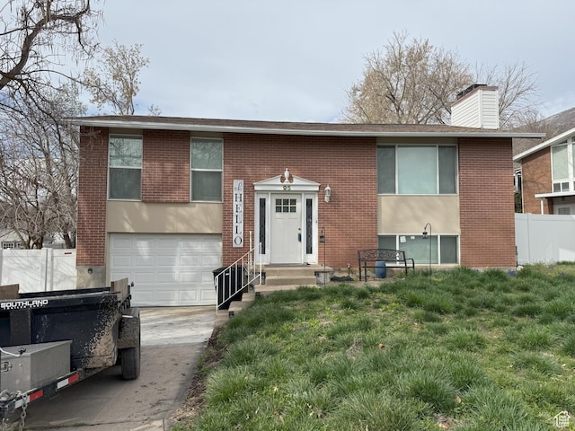95 E Continental Dr S Unit 61-G, Farmington, UT 84025 - bi-level home featuring concrete driveway, a chimney, fence, brick siding, and a garage