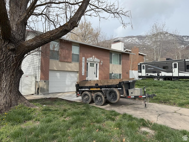 95 E Continental Dr S Unit 61-G, Farmington, UT 84025 - view of front facade with a chimney, a garage, brick siding, driveway, and a mountain view