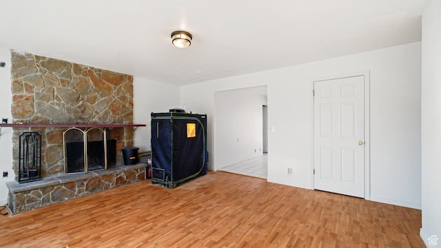 5488 S Hollow Springs Cir W, Murray, UT 84123 - unfurnished living room with a stone fireplace, baseboards, and wood finished floors