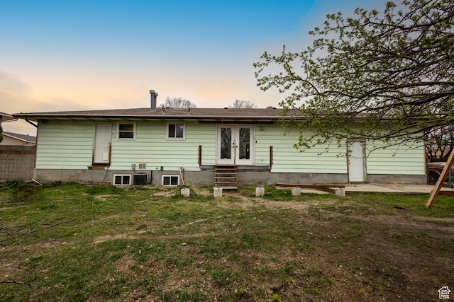 5488 S Hollow Springs Cir W, Murray, UT 84123 - back of house at dusk with entry steps, french doors, and a lawn